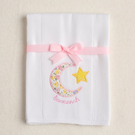 White burp pad made from an all cotton diaper that is hand appliqued with a pink floral moon and stars motif for that sweet baby gift.  Pink floral fabric is reminiscent of a Liberty of London fabric.