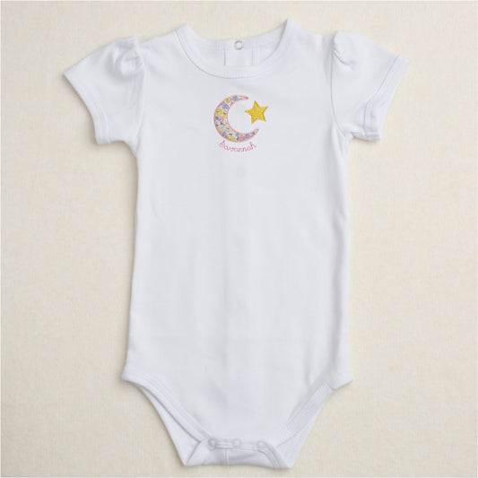 all white onesie with puffed sleeves and the Deacon Lane signature moon and stars applique