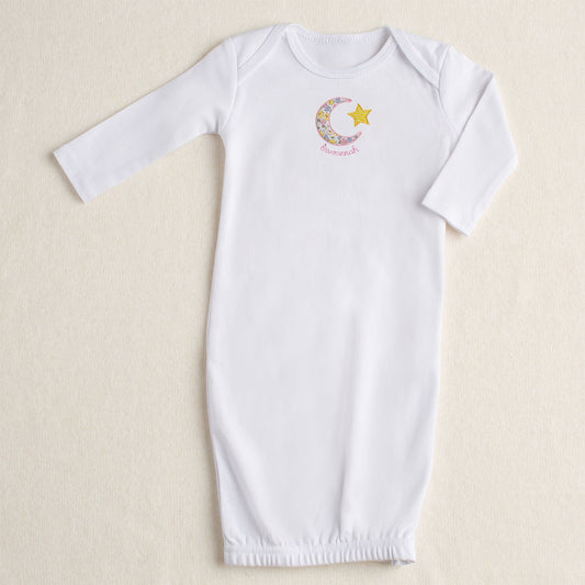 A white cotton gown in NB - 3 Months that features a zipper closure at the bottom and sports a handmade applique motif made from a Liberty of London like floral print in pink, yellow, and lavender.