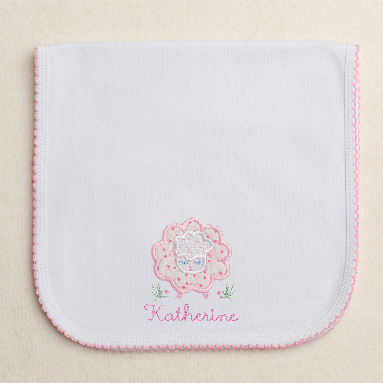 Picot trimmed burp pad with pink floral sheep applique and embroidered name