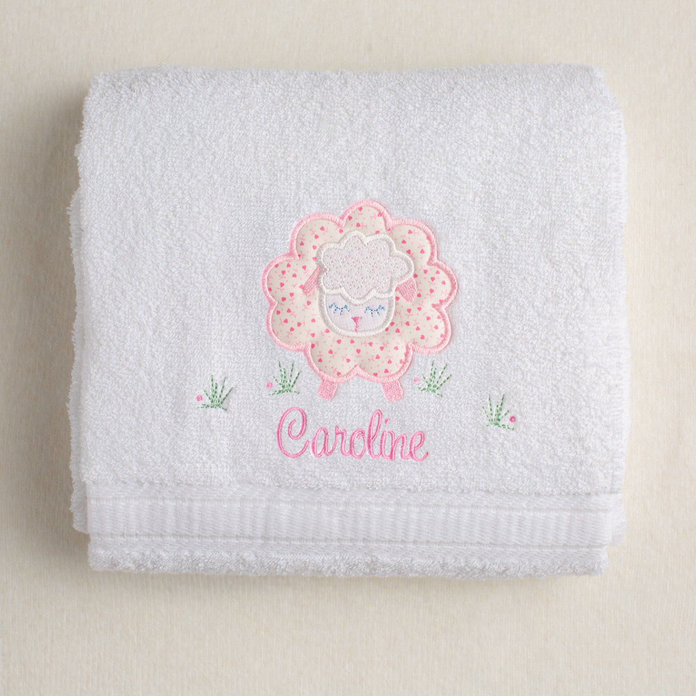 white bath towel hand made in the USA with fabric applique of a charming pink sheep for boutique baby gift giving
