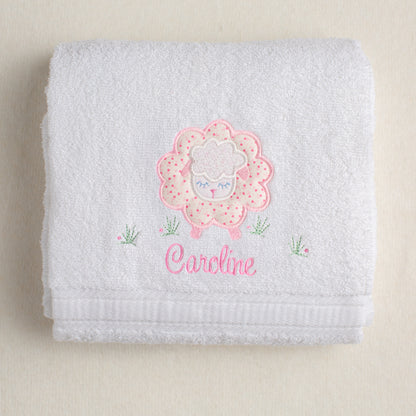 white bath towel hand made in the USA with fabric applique of a charming pink sheep for boutique baby gift giving
