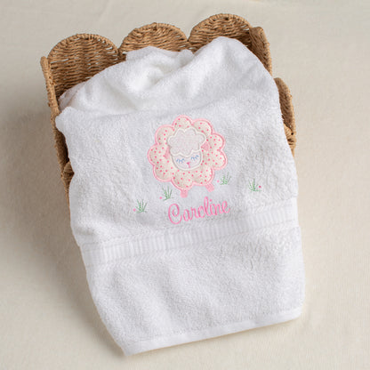 Fluffy white bath towel with a signature Deacon Lane design of a pink floral fluffy sheep applique with a custom personalized name