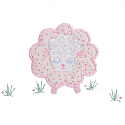 close-up of a hand made applique of a pink floral sheep with darling pink ears and feet