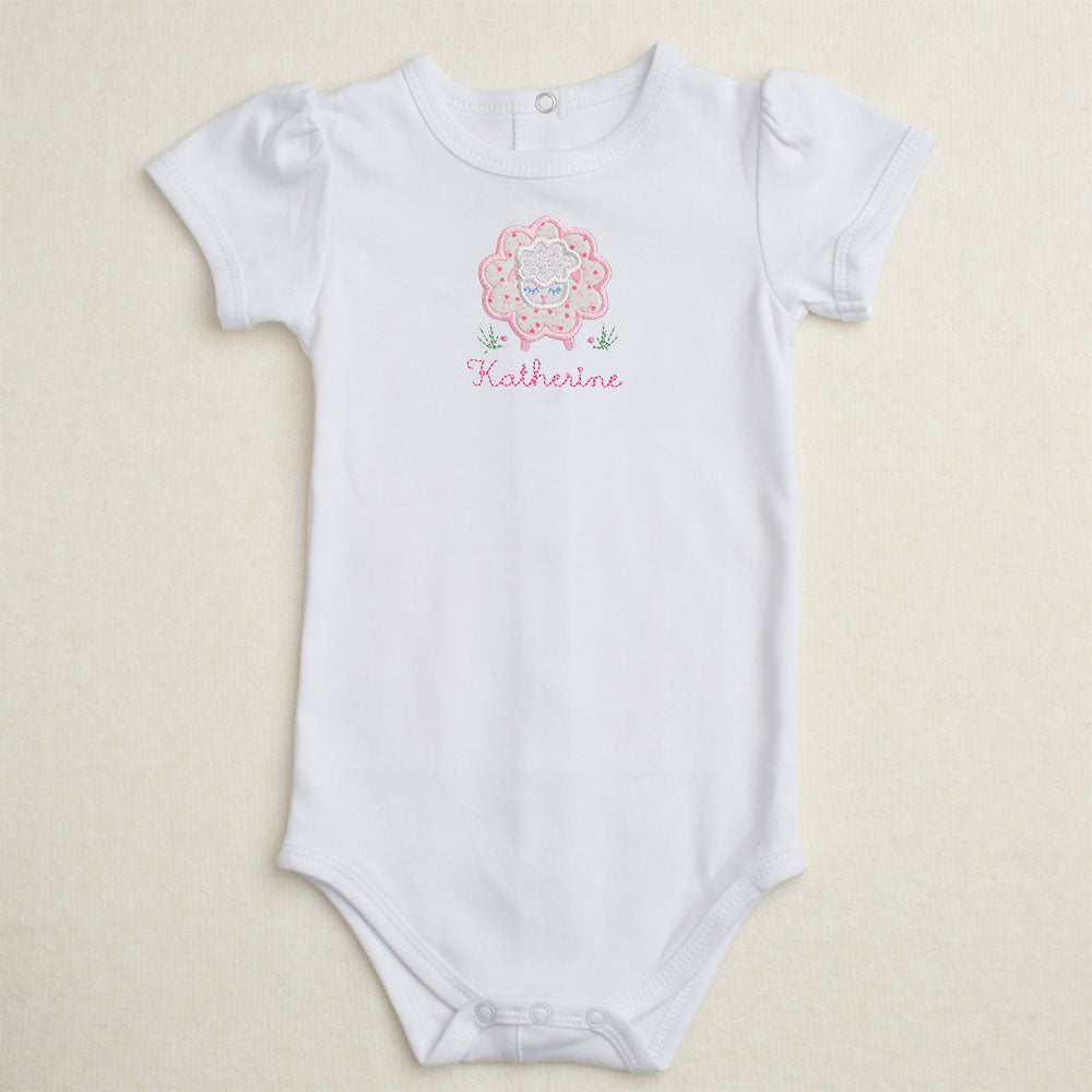 All cotton bodysuit with short puff sleeves and a pink sheep applique that can be personalized with embroidery