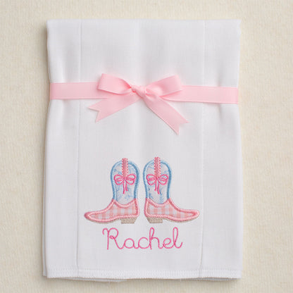 Detail of the pink check/blue toile cowboy boots applique and personalized embroidered name on the cloth diaper burp pad.  Burp pad is folded and tied with a grosgrain ribbon for gift giving.