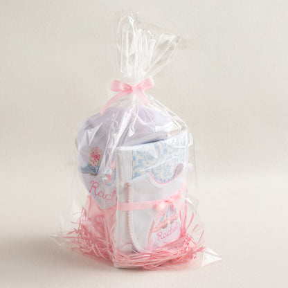 Personalized baby gift set with a Shabby Chic Cowgirl motif featuring appliqued cowboy boots in pink check and blue toile.  Includes a hooded towel, a fabric burp pad, and a personalized bib.  Wrapped in clear cello for easy gift giving.