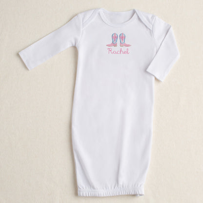 White baby gown with appliqued Shabby Chic Cowgirl boots featuring a blue floral toile fabric and personalized with a name on a beige background