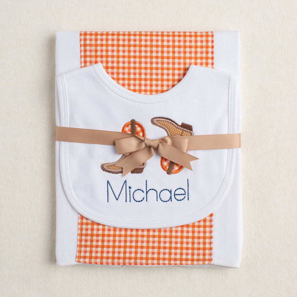 2 piece gift set from Deacon Lane with applique cowboy boots in burnt orange and a burp pad.