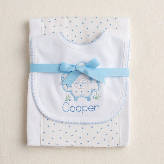 hand made baby gift set with cotton bib with appliqued sheep and a burp pad with a fabric panel of blue stars down the center
