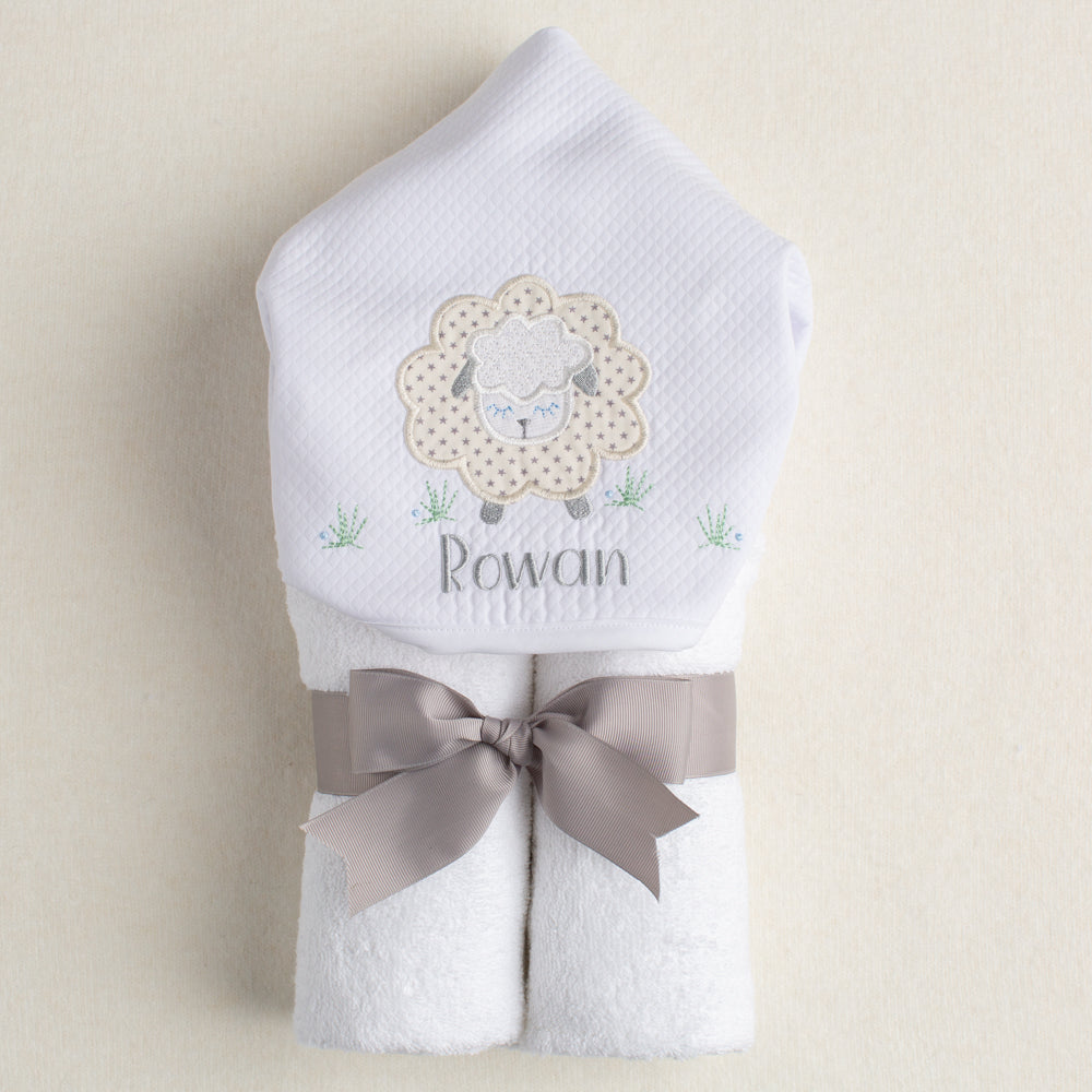 perfect personalized baby gift is a hooded towel with a grey sheep applique and an embroidered personalized name.  Rolled and tied with a grey grosgrain ribbon.