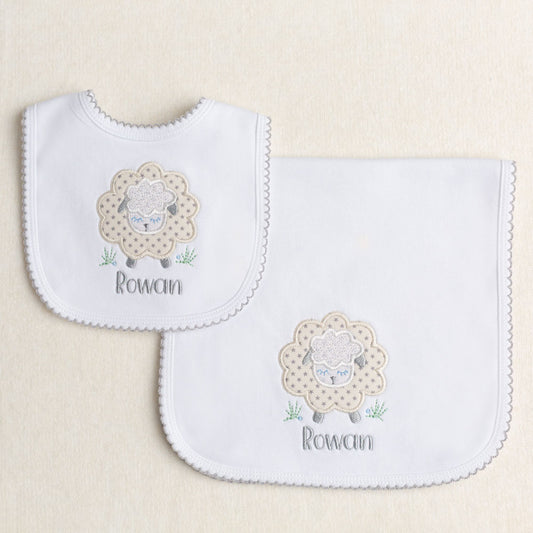Boutique baby personalized gift set with a cotton bib and burp pad both with picot trim and an applique of a grey sheep for gender neutral gift giving