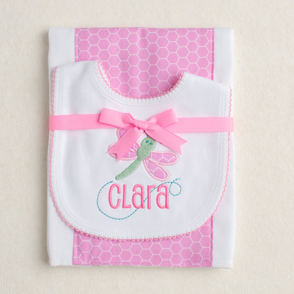2 piece gift set with a bib appliqued with a pink and green dragonfly and personalized with a name paired with a pink hex fabric burp cloth.
