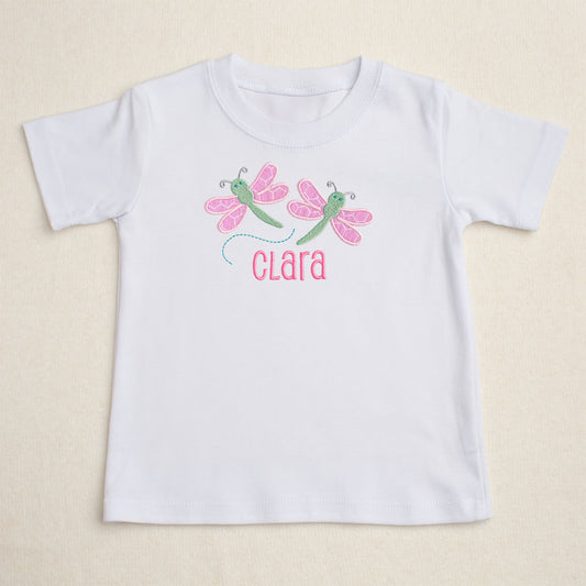 white t-shirt featuring Deacon Lane's exclusive pink dragonflies applique design in pink hex fabric along with personalization with an embroidered custom name 