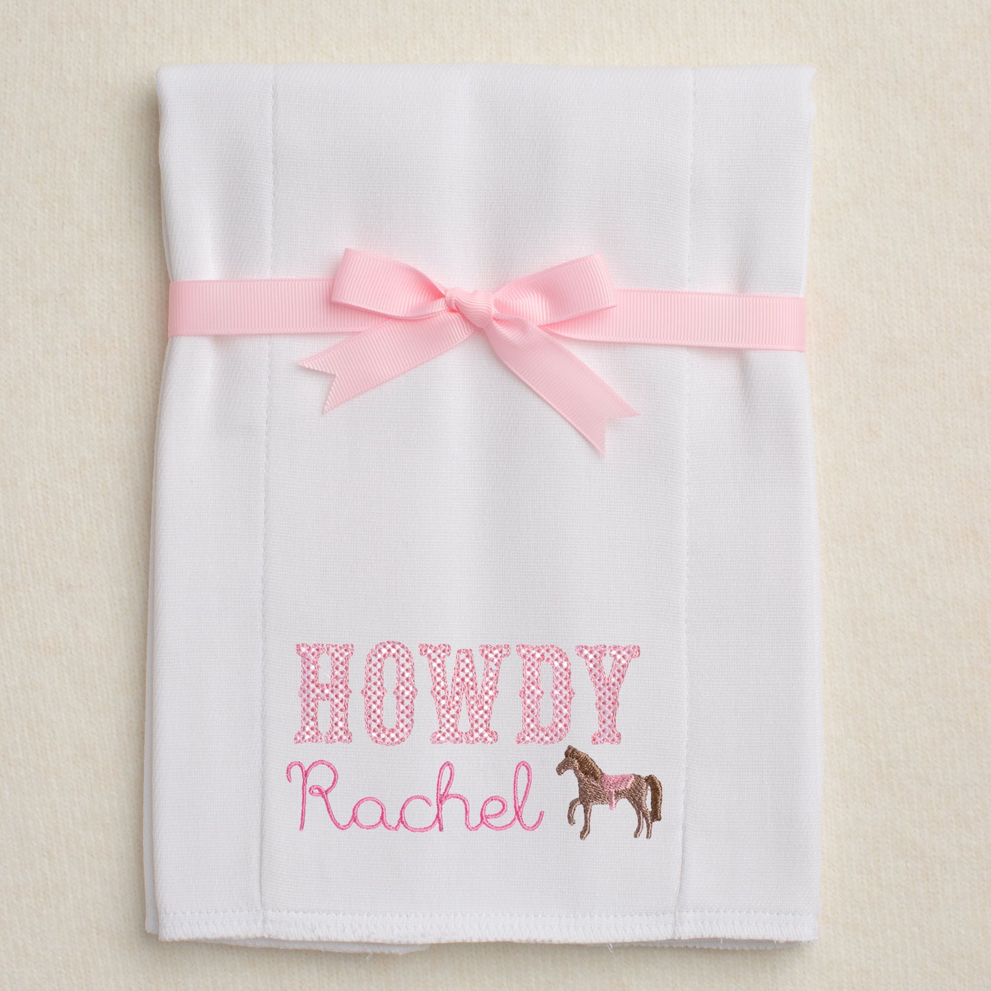 white burp pad made from a cloth diaper with Howdy Rachel embroidered on it in addition to a mini horse embroidery.  Hand made personalized boutique baby gift
