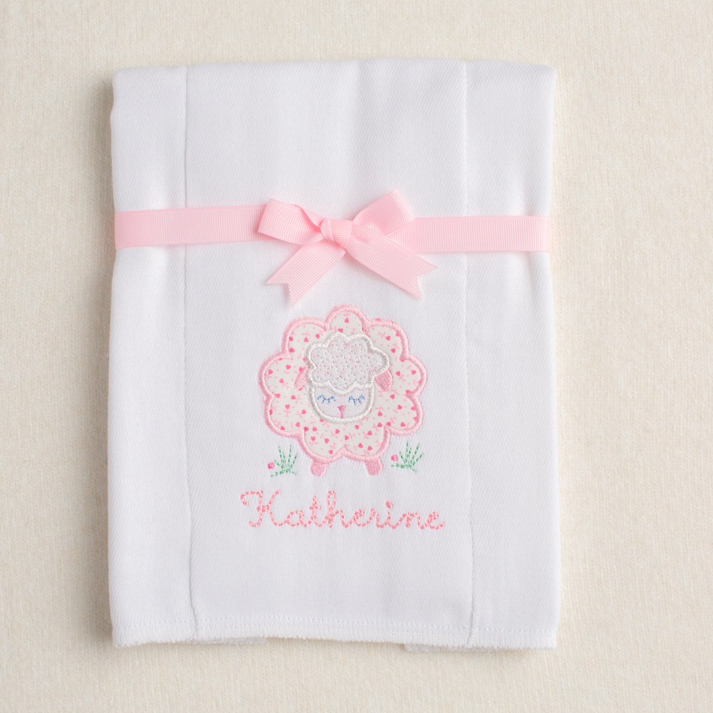 hand made cotton burp pad with pink floral sheep applique folded and tied with ribbon for boutique baby gift giving