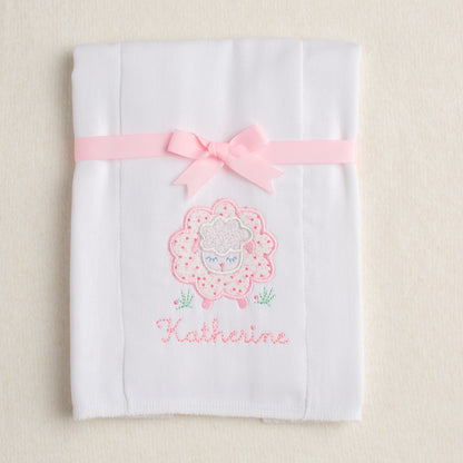 hand made cotton burp pad with pink floral sheep applique folded and tied with ribbon for boutique baby gift giving